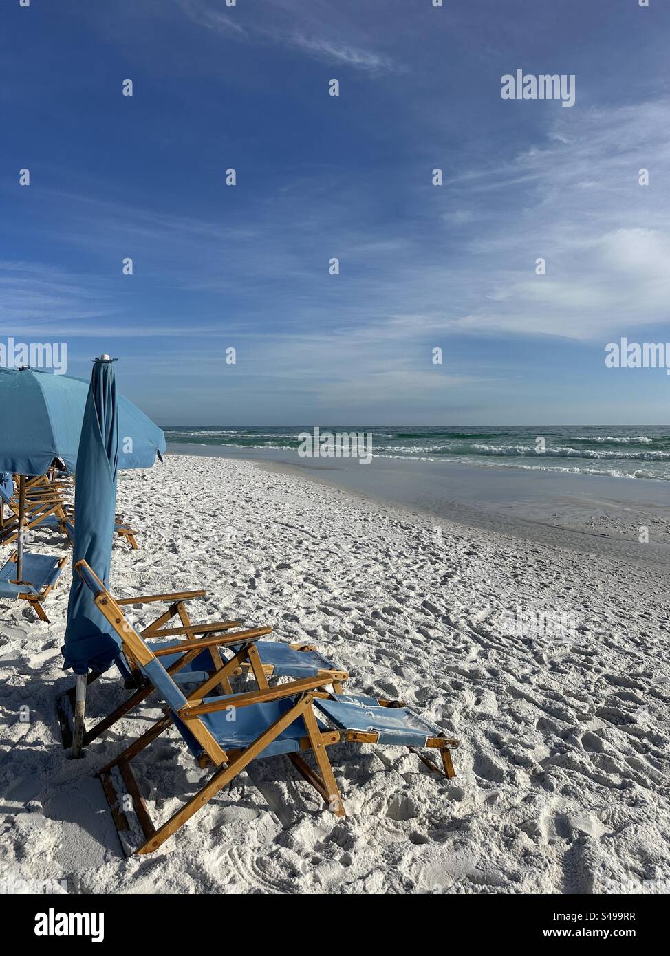 Blue lounge chairs and umbrellas with views of the Gulf of Mexico water - Smartphone Captured Stock Image