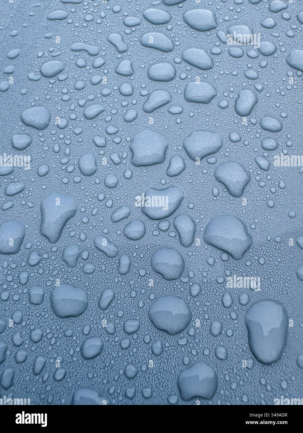 Raindrops on a grey metallic surface Stock Photo