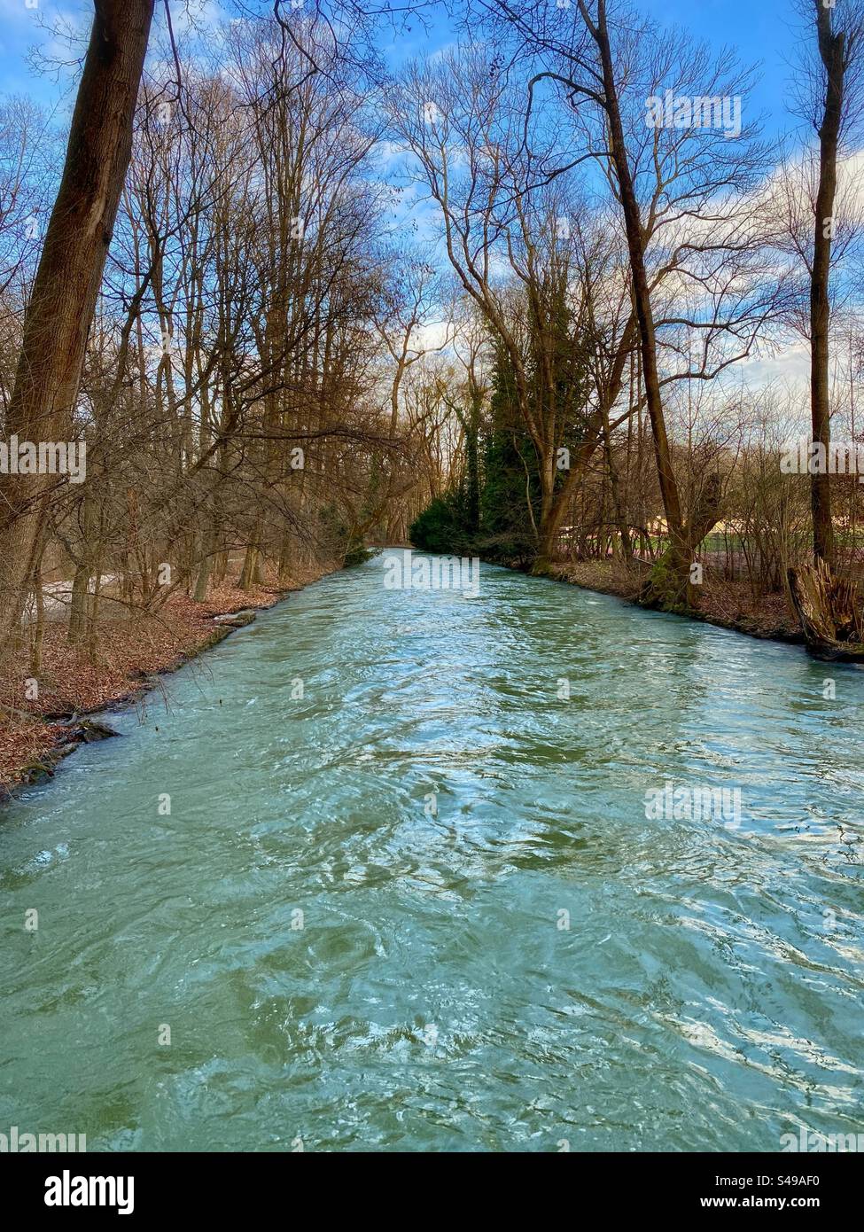 River flowing on a winter sunny day through English Garden city park in Munich, Germany. - Smartphone Captured Stock Image