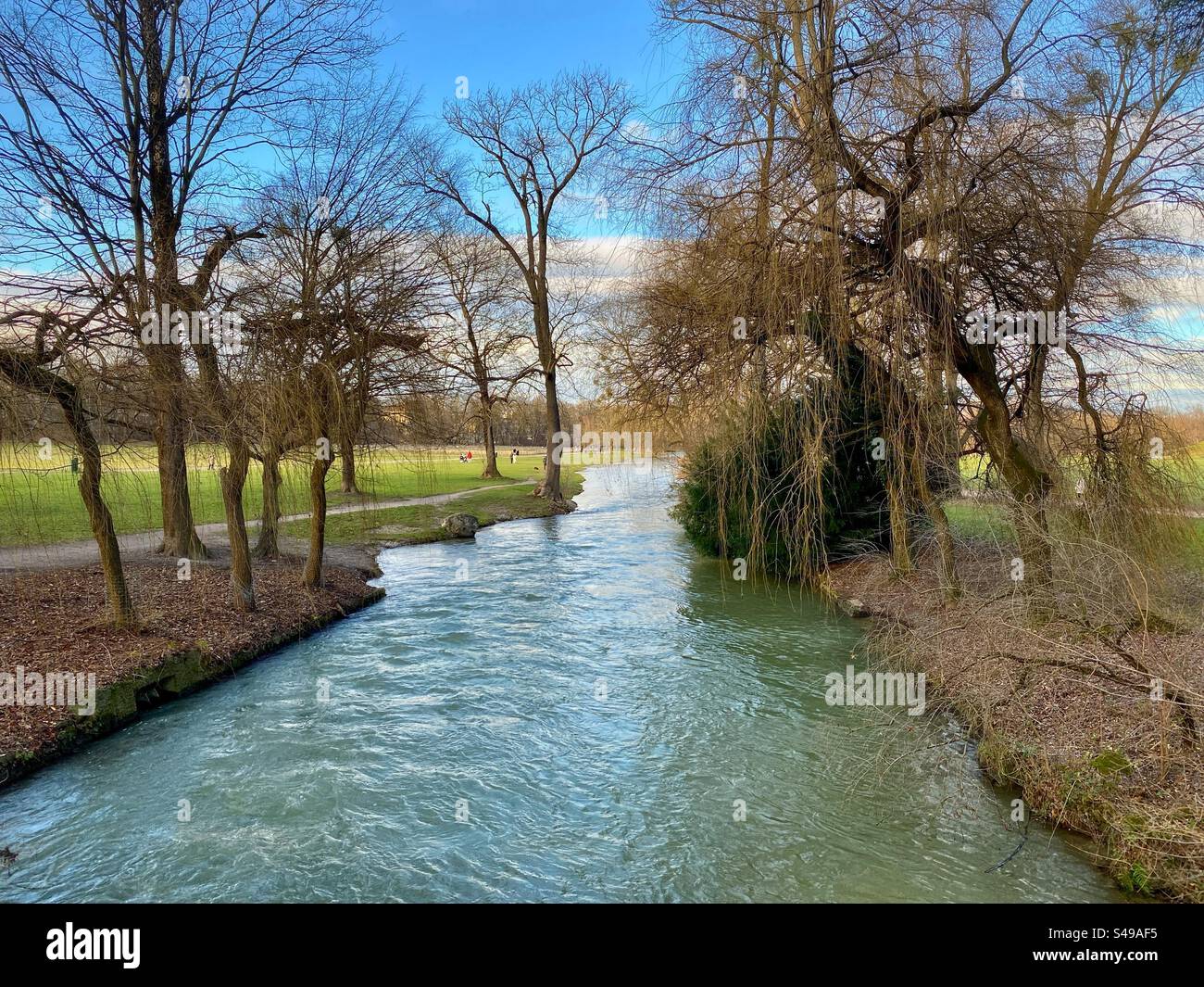 Winter scenery with river flowing through English Garden city park in Munich, Germany. - Smartphone Captured Stock Image