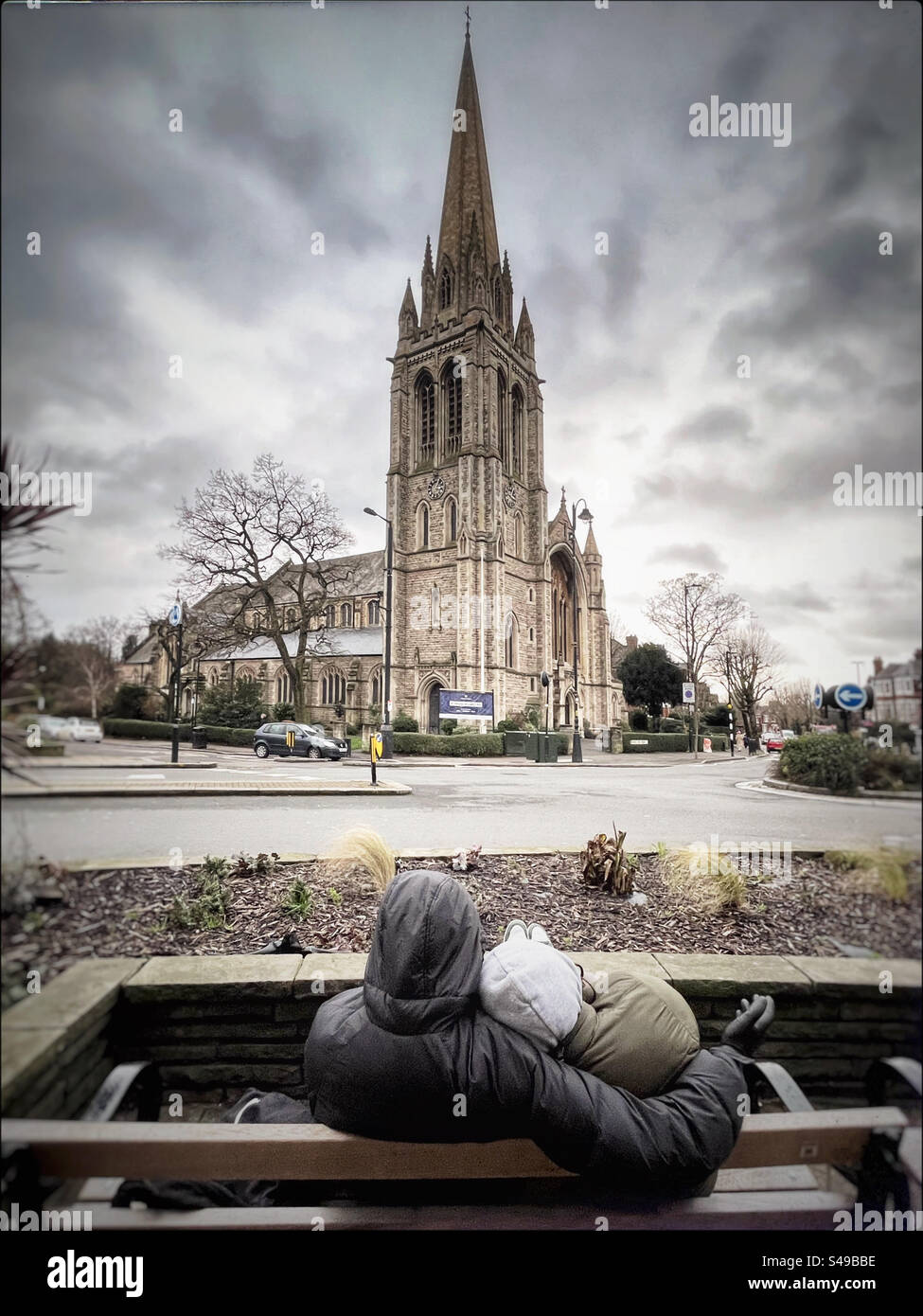 Couple on bench in front of St James Church, Muswell Hill, London - Smartphone Captured Stock Image