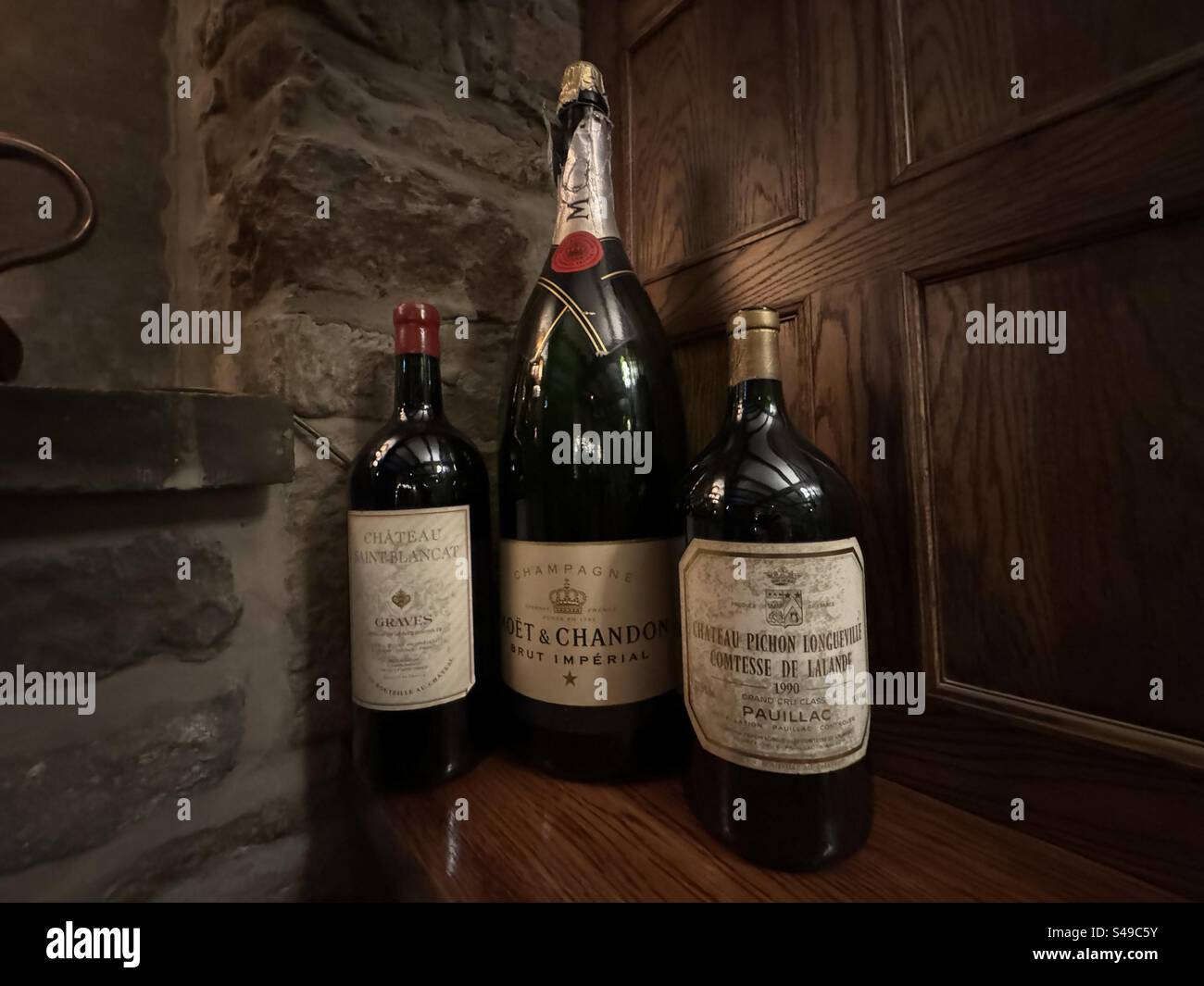 Three old bottles of alcohol on a shelf Stock Photo Alamy