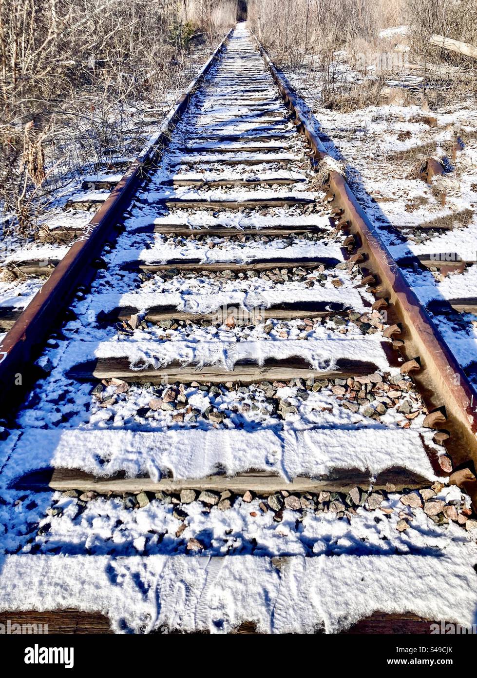 Decommissioned railway line covered in snow. Stock Photo