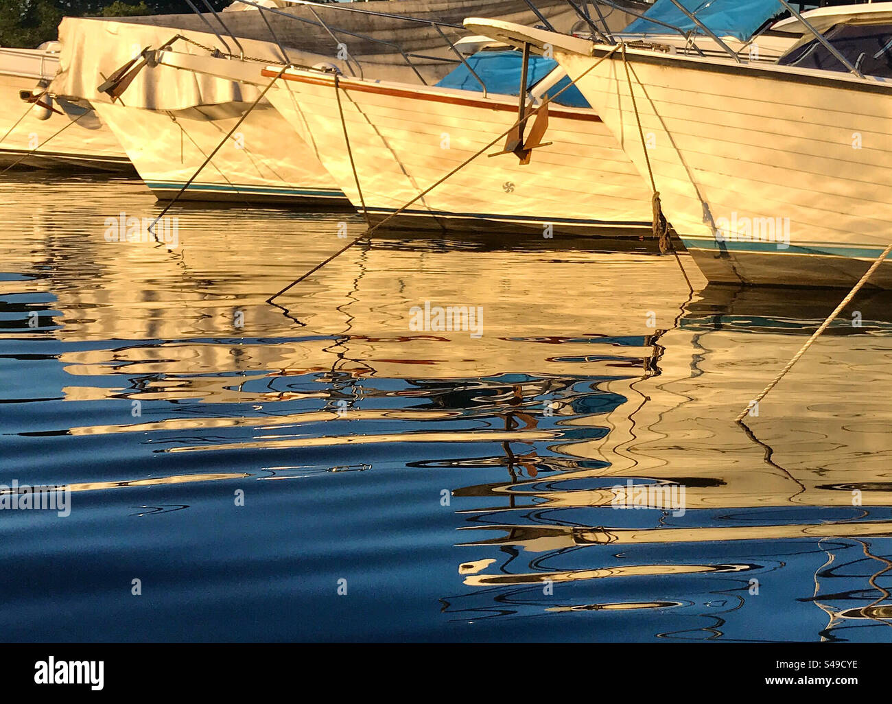 boats moored in the port with reflections in the water Stock Photo