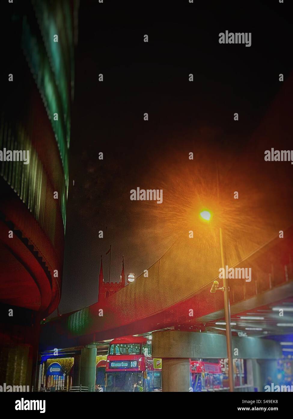 London Bridge station looking towards the ancient Southwark Cathedral in London at night with the railway line viaduct and buses underneath. Urban city life in south east London - Smartphone Captured Stock Image