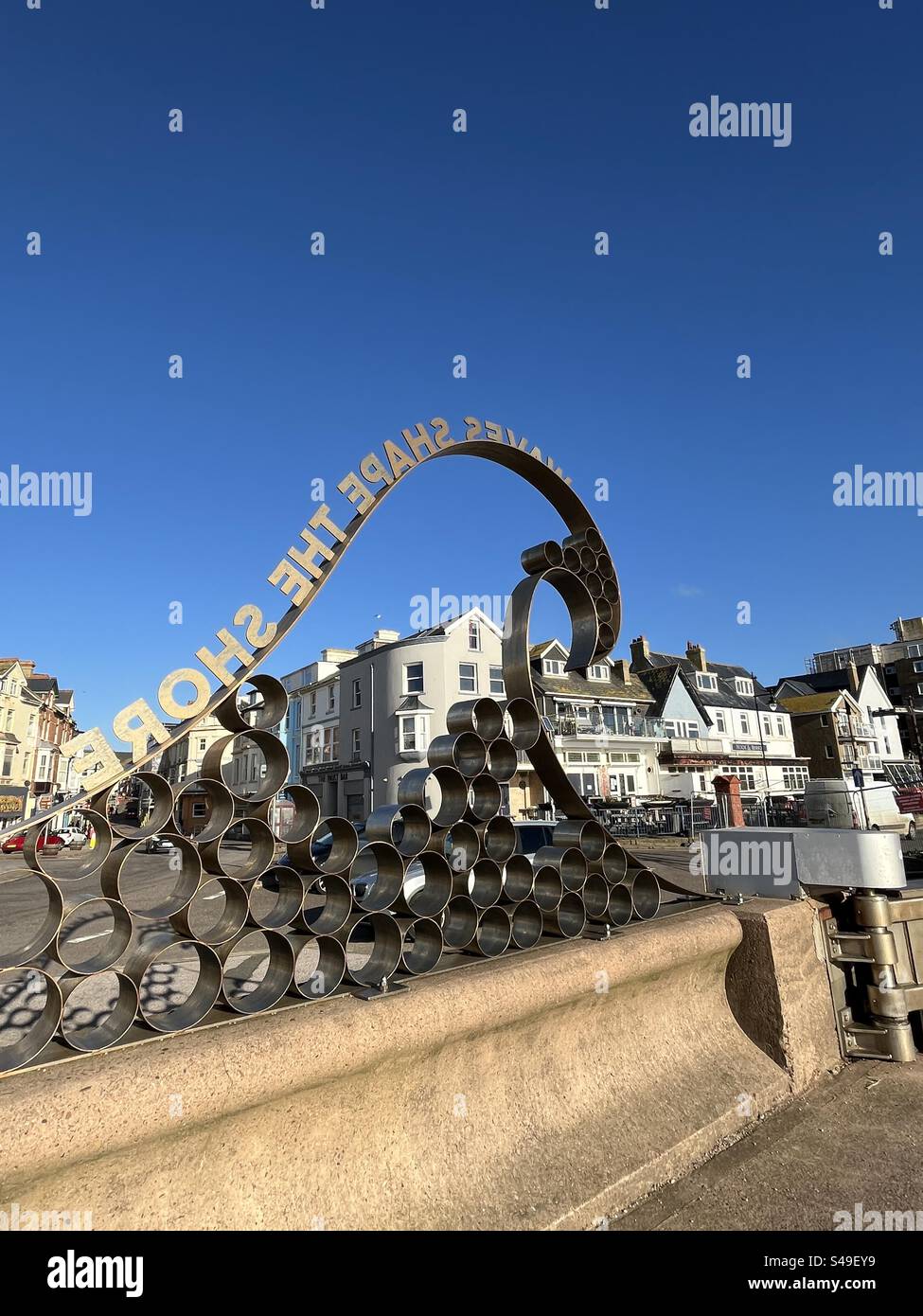 ‘Waves Shape the Shore' on the sea wall at Seaton in Devon - Smartphone Captured Stock Image
