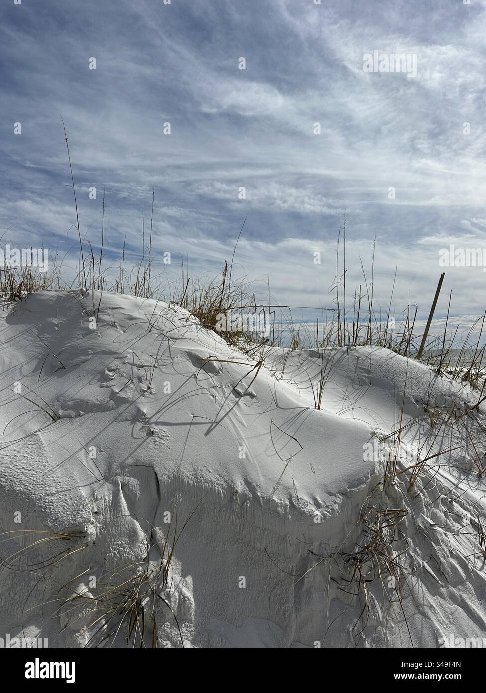 Large wind blown beach sand dune with soft white cloud background - Smartphone Captured Stock Image