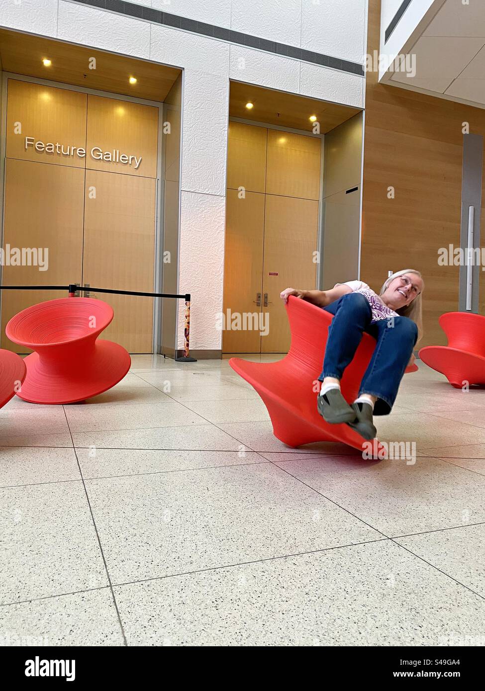A middle-aged woman spins on an oversized top. - Smartphone Captured Stock Image