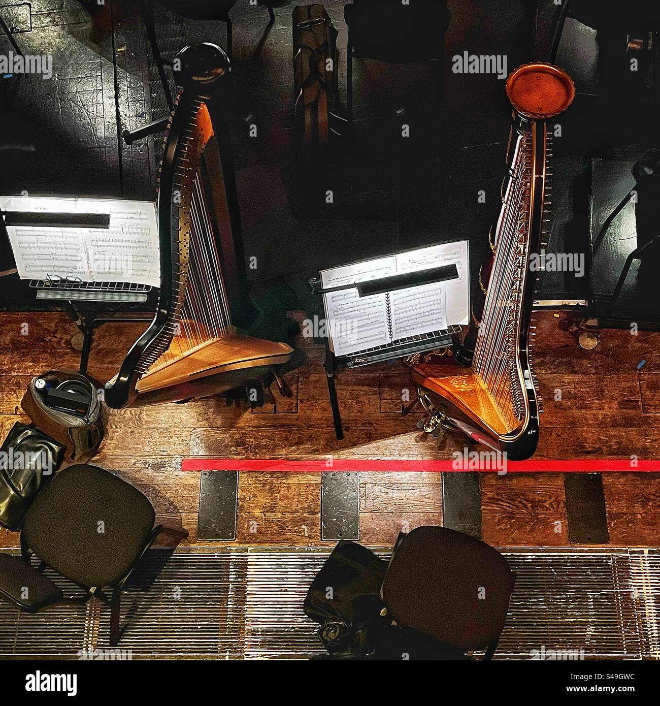 Two harps - looking into the orchestra pit a the Royal Opera House in London. Music on the stand is ‘Manon’ - the ballet - Smartphone Captured Stock Image