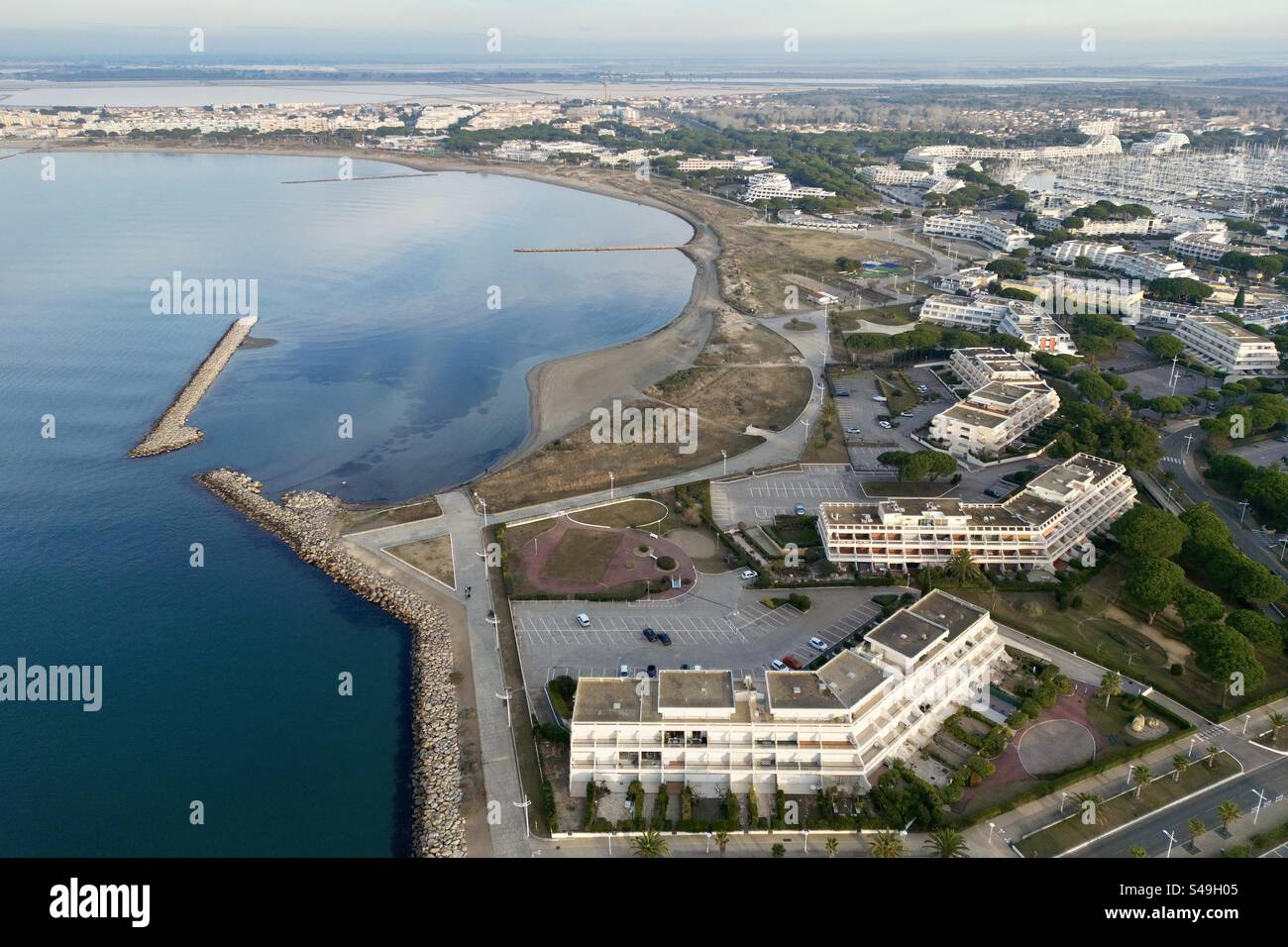 Aerial drone shot of the beach and modern seafront residential buildings in Port Camargue, Occitanie, France. - Smartphone Captured Stock Image