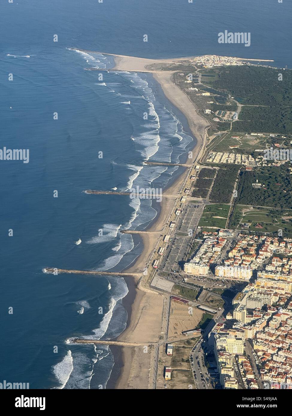 Aerial view of Lisbon, Portugal, showcasing the beach shoreline with white sand and Atlantic Ocean waves. - Smartphone Captured Stock Image