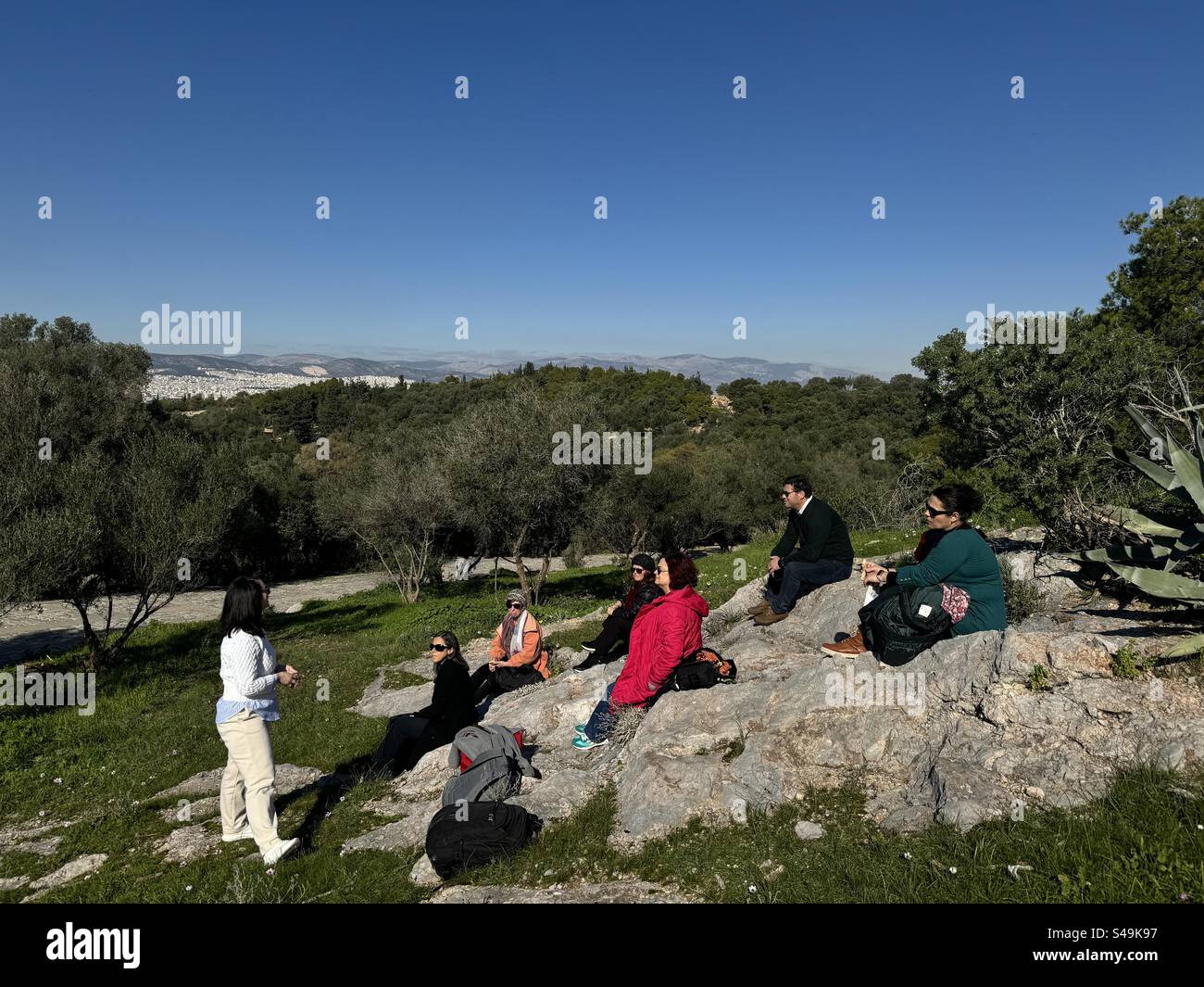Teacher leading an outdoor class for adults on Pnyx Hill in Athens, Greece. - Smartphone Captured Stock Image