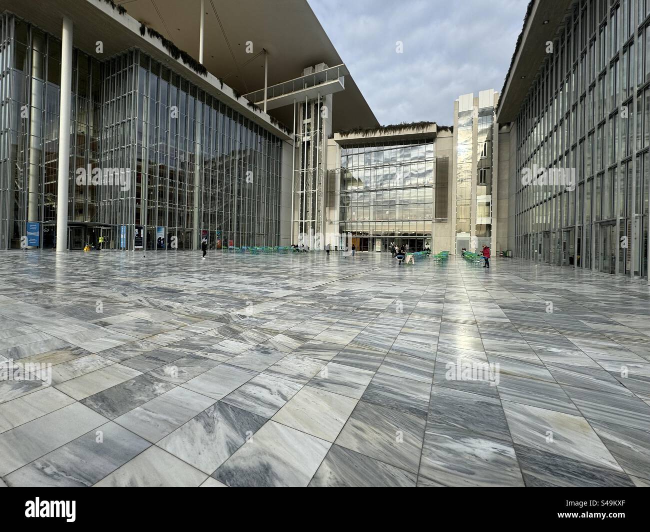 The Stavros Niarchos Foundation (SNF) Cultural Center plaza with marble paving and modern glass façades in Athens, Greece. - Smartphone Captured Stock Image The Stavros Niarchos Foundation (SNF) Cultural Center plaza with marble paving and modern glass façades in Athens, Greece. - Smartphone Captured Stock Image