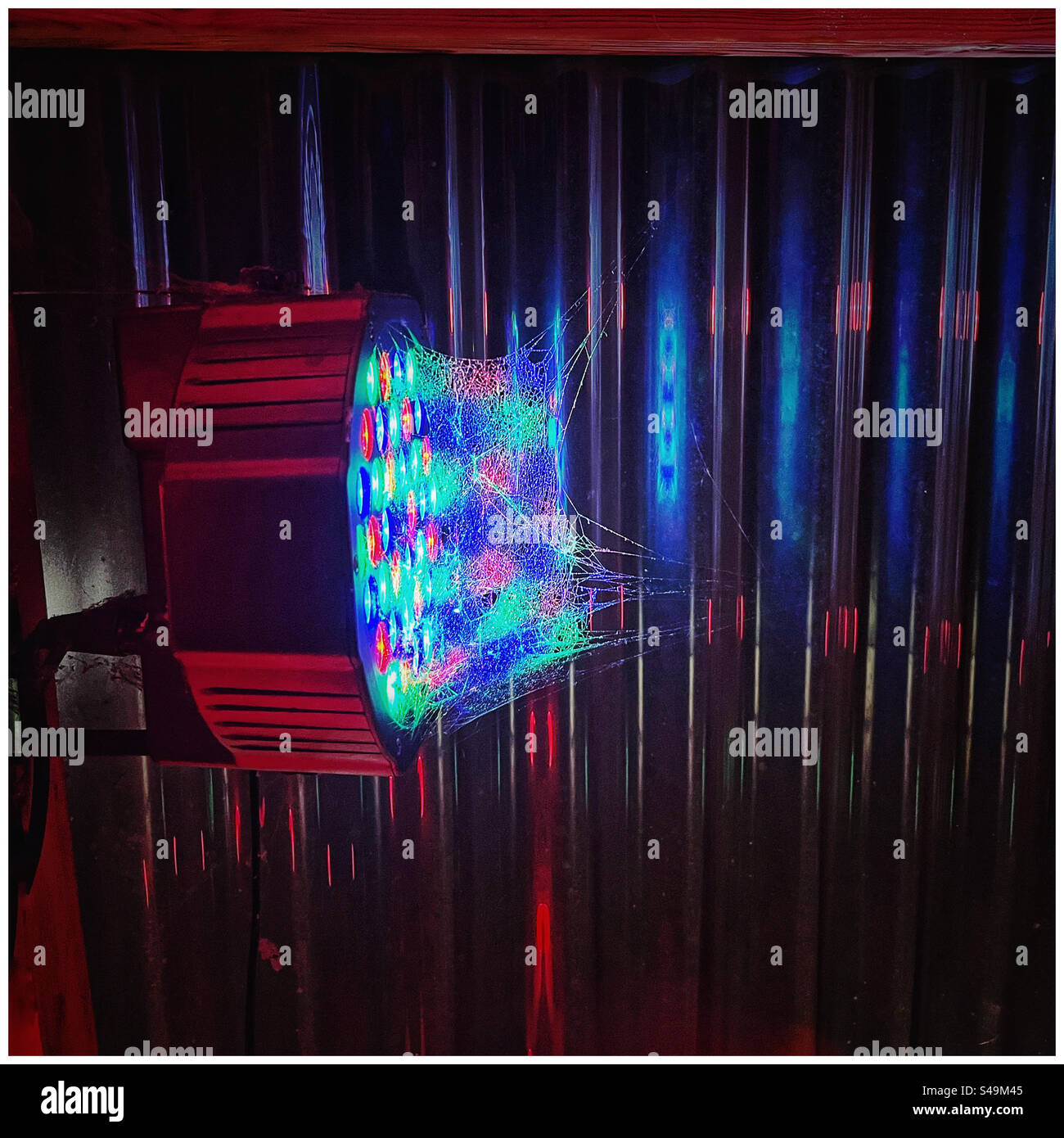 Cobweb illuminated by a disco light - Smartphone Captured Stock Image
