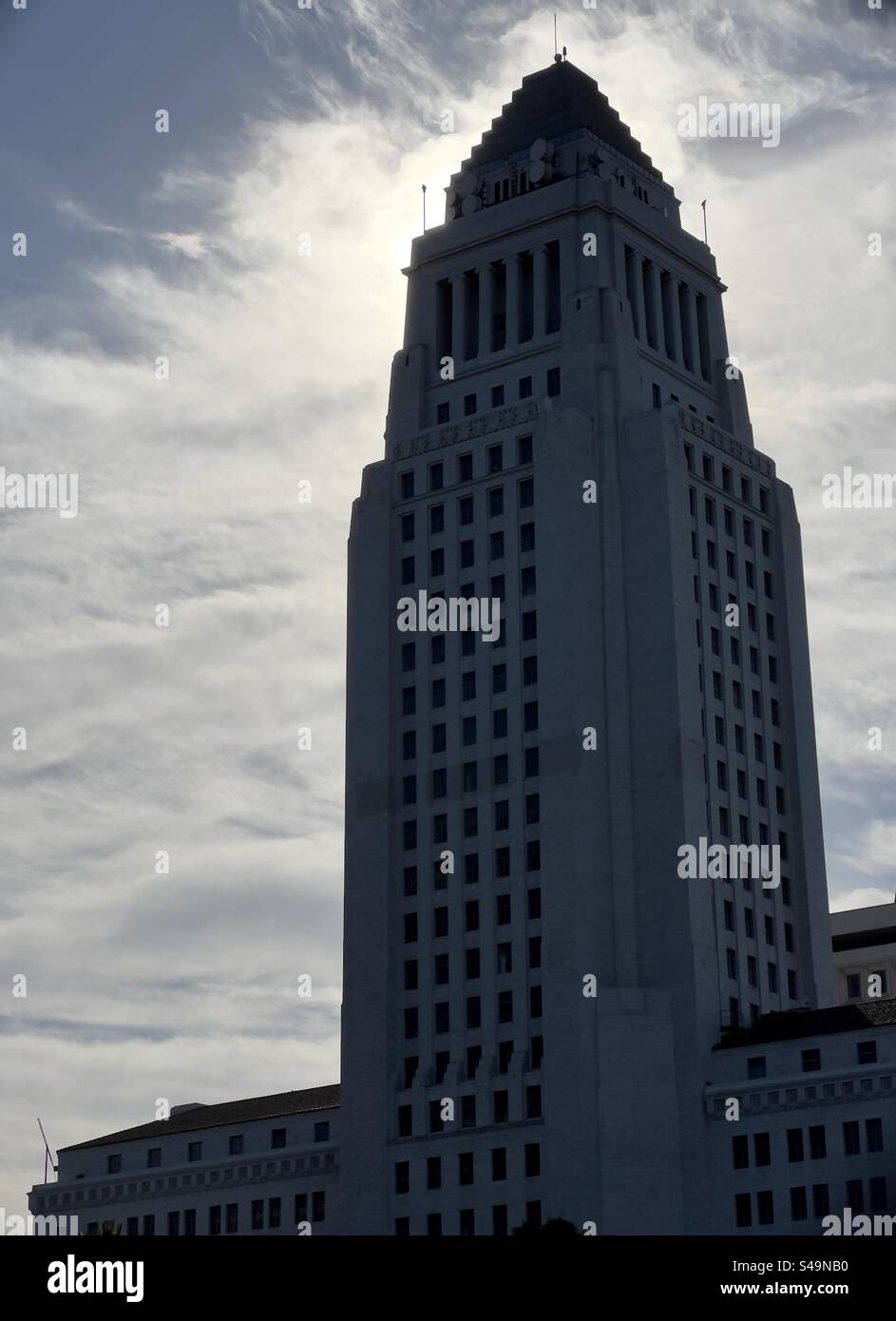 LOS ANGELES, CA, AUG 19, 2023: silhouetted view of City Hall in civic center area of Downtown, early morning, sun obscured by clouds - Smartphone Captured Stock Image