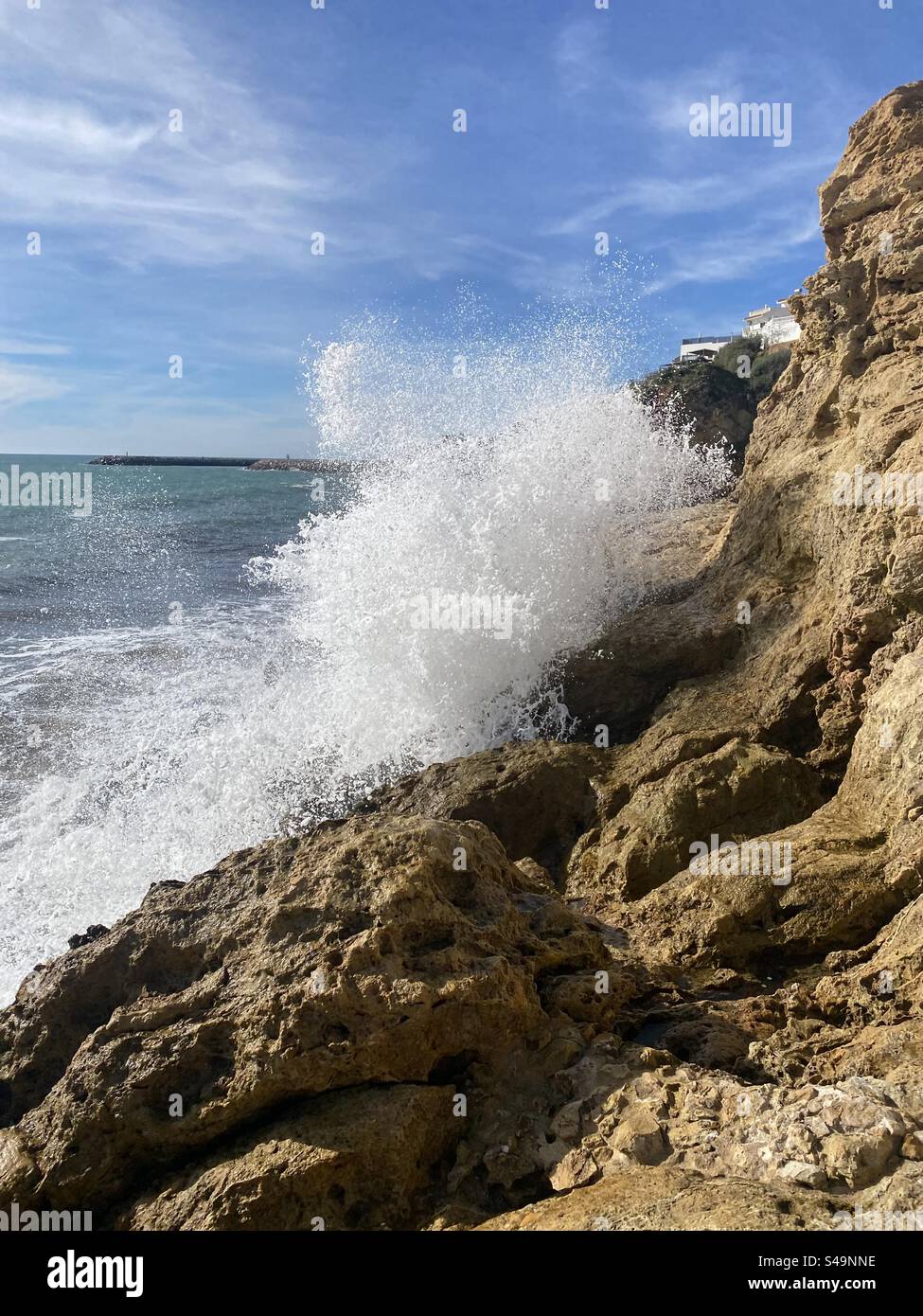 Water, splashing on the rocks on the beach in Albufeira in Portugal - Smartphone Captured Stock Image