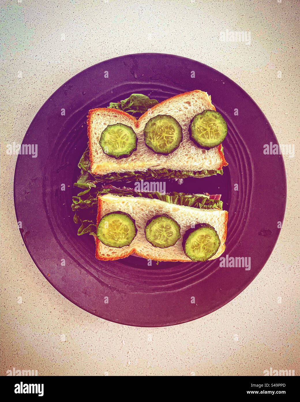Simple Bread Sandwish snack with cucumber top view with sald in a purple violet plate on a table in a kitchen healthy food to eat - Smartphone Captured Stock Image