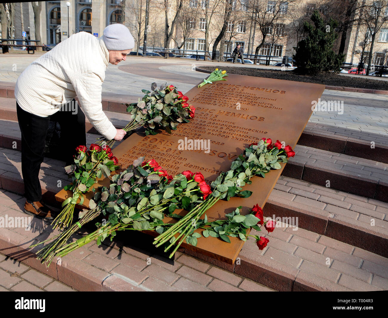 Kiev, Ukraine. 15th March 2019. An old woman seen laying down flowers on the Boris Nemtsov plaque inside the square named after his name during the opening day. The Russian opposition leader Boris Nemtsov was killed 4 years ago in the center of Moscow on February 27, 2015. In the murder case, five Chechen natives were convicted and found guilty of the crime. Credit: SOPA Images Limited/Alamy Live News Stock Photo