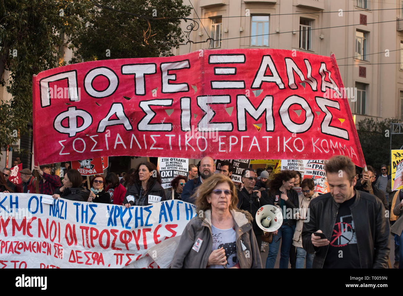 Athens, Greece. 16th March 2019. A banner reads, 'Never again fascism', as locals, migrants and refugees hold placards and shout slogans against racism and closed borders. Leftist and anti-racist organizations staged a rally on the occasion of the International Day against racism to demonstrate against discrimination and racist policies and behaviours. © Nikolas Georgiou / Alamy Live News Stock Photo