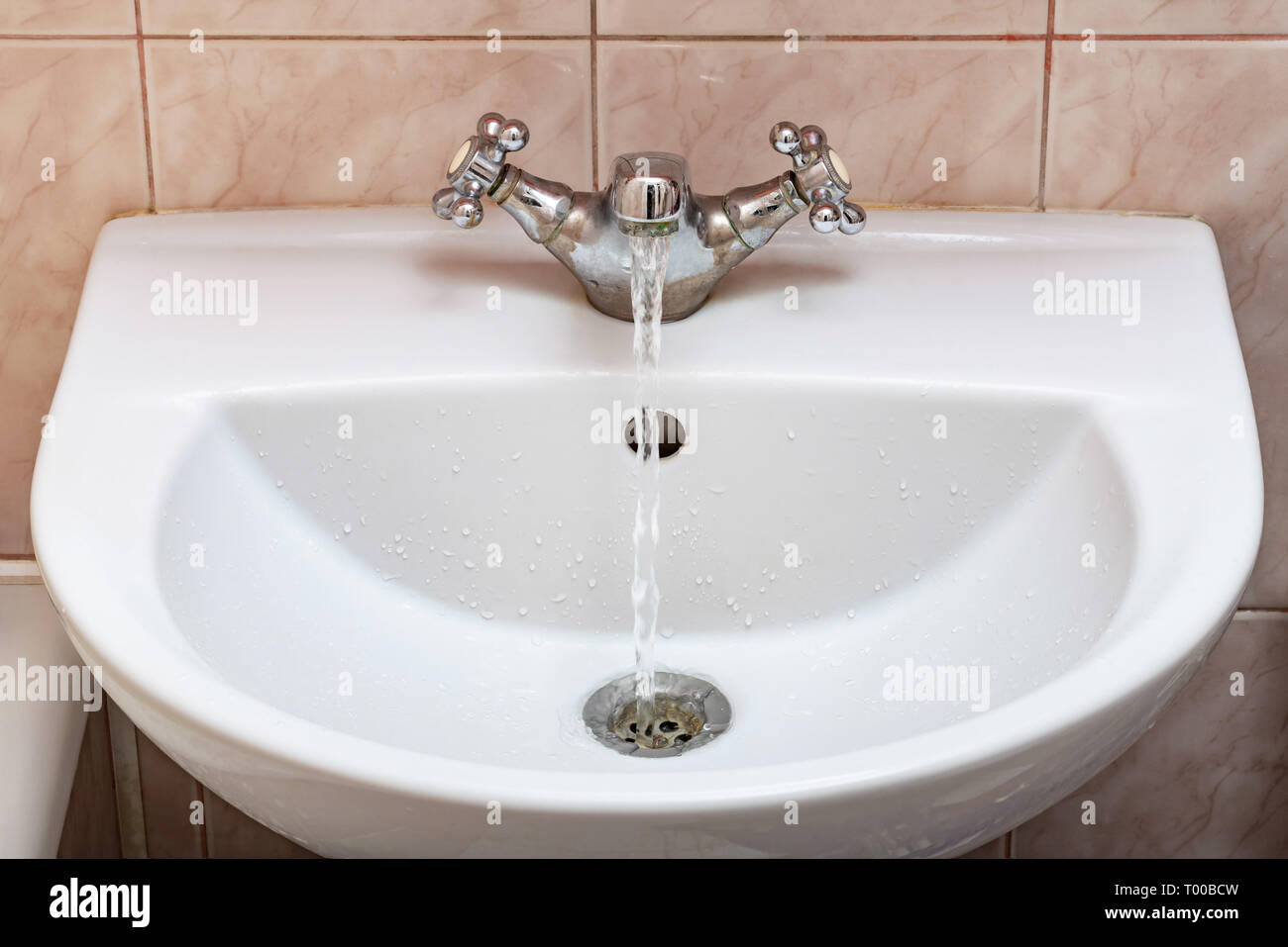 Horizontal image of a tap with water flowing strongly under high pressure Stock Photo