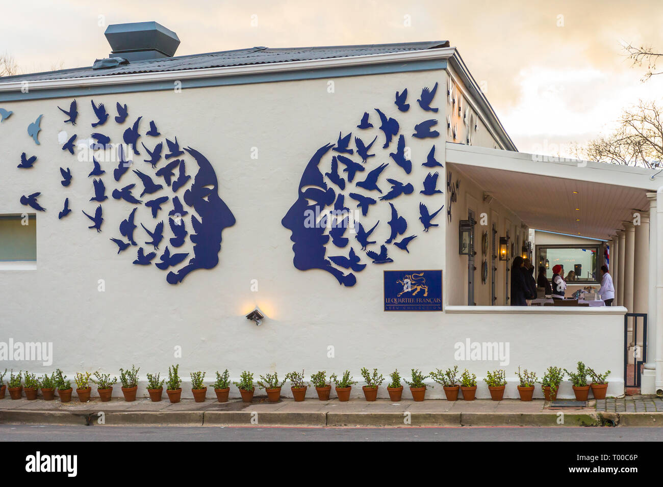 Cape Winelands le quartier français boutique hotel and restaurant in Franschhoek, street art on the side of the building with two blue faces and birds Stock Photo