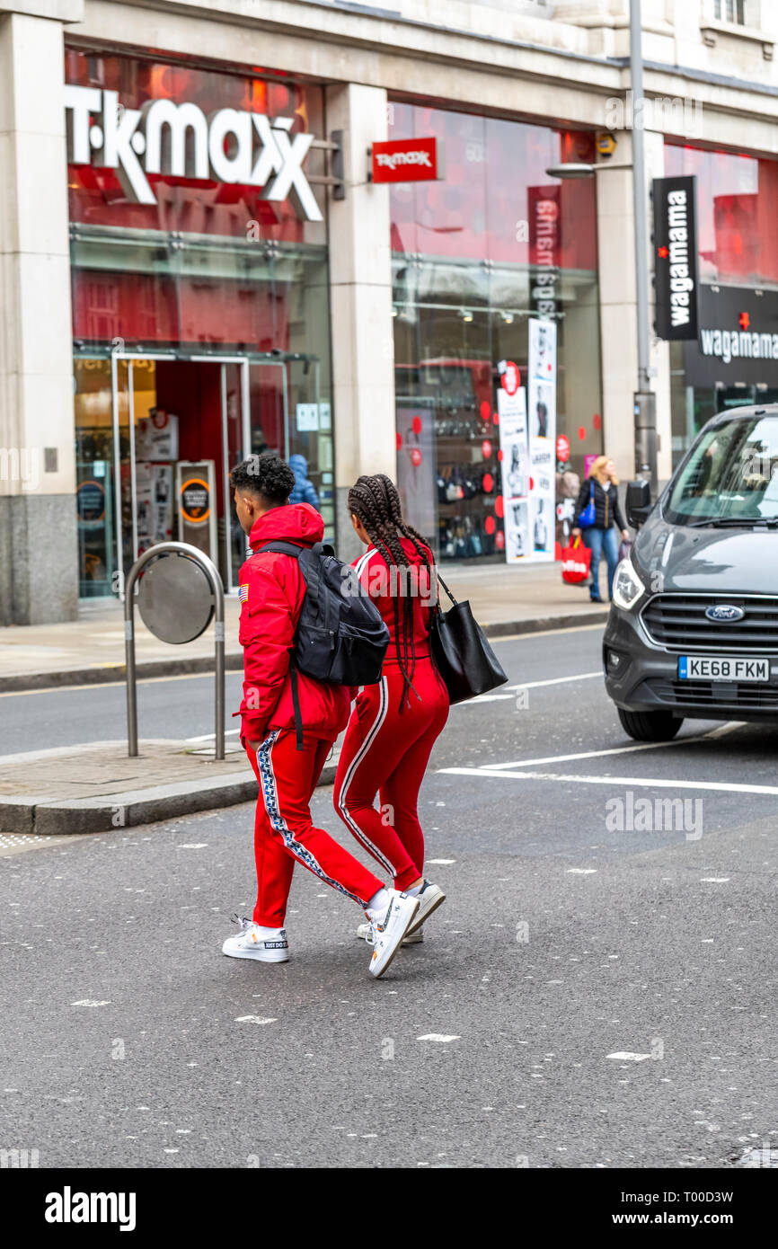 A fashionable couple on Kensington High Street wearing matching red track suits. London Stock Photo Alamy