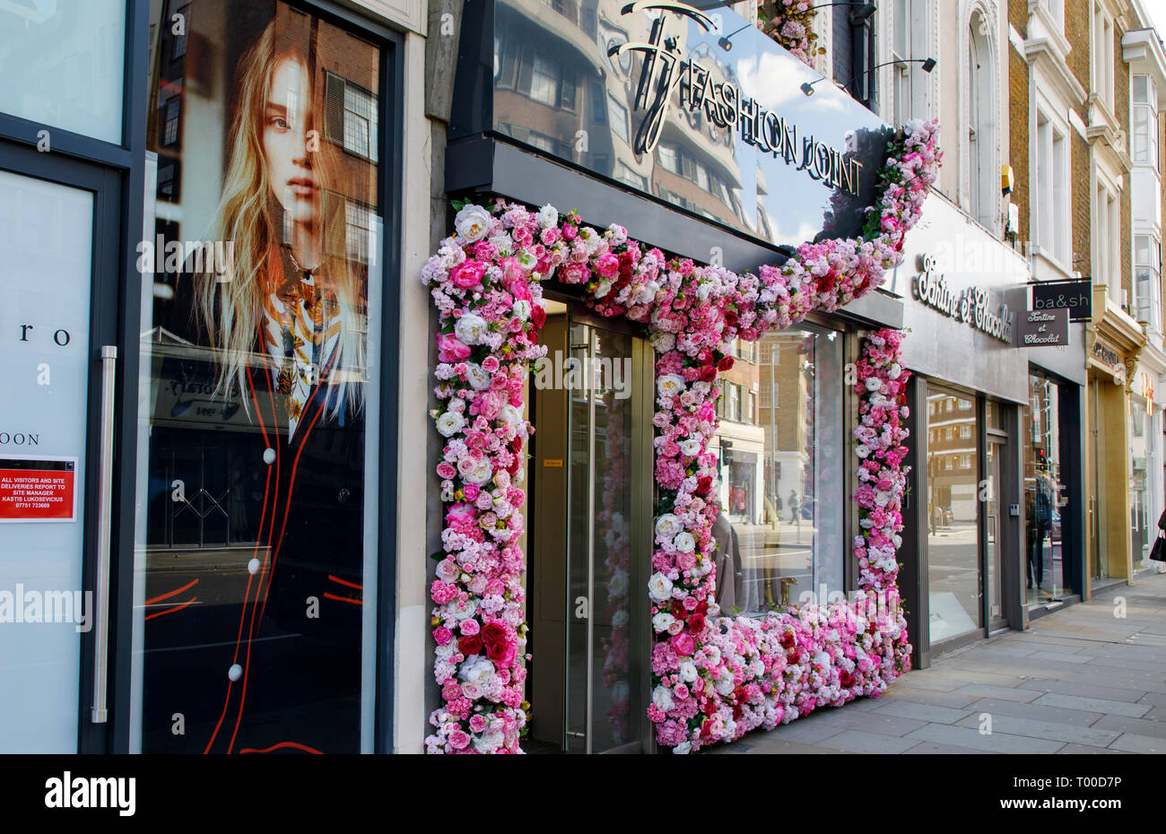 LONDON, UNITED KINGDOM - MARCH 11th, 2019: Store fronts in stylish Chelsea are in Central London are decorated with floral display Stock Photo