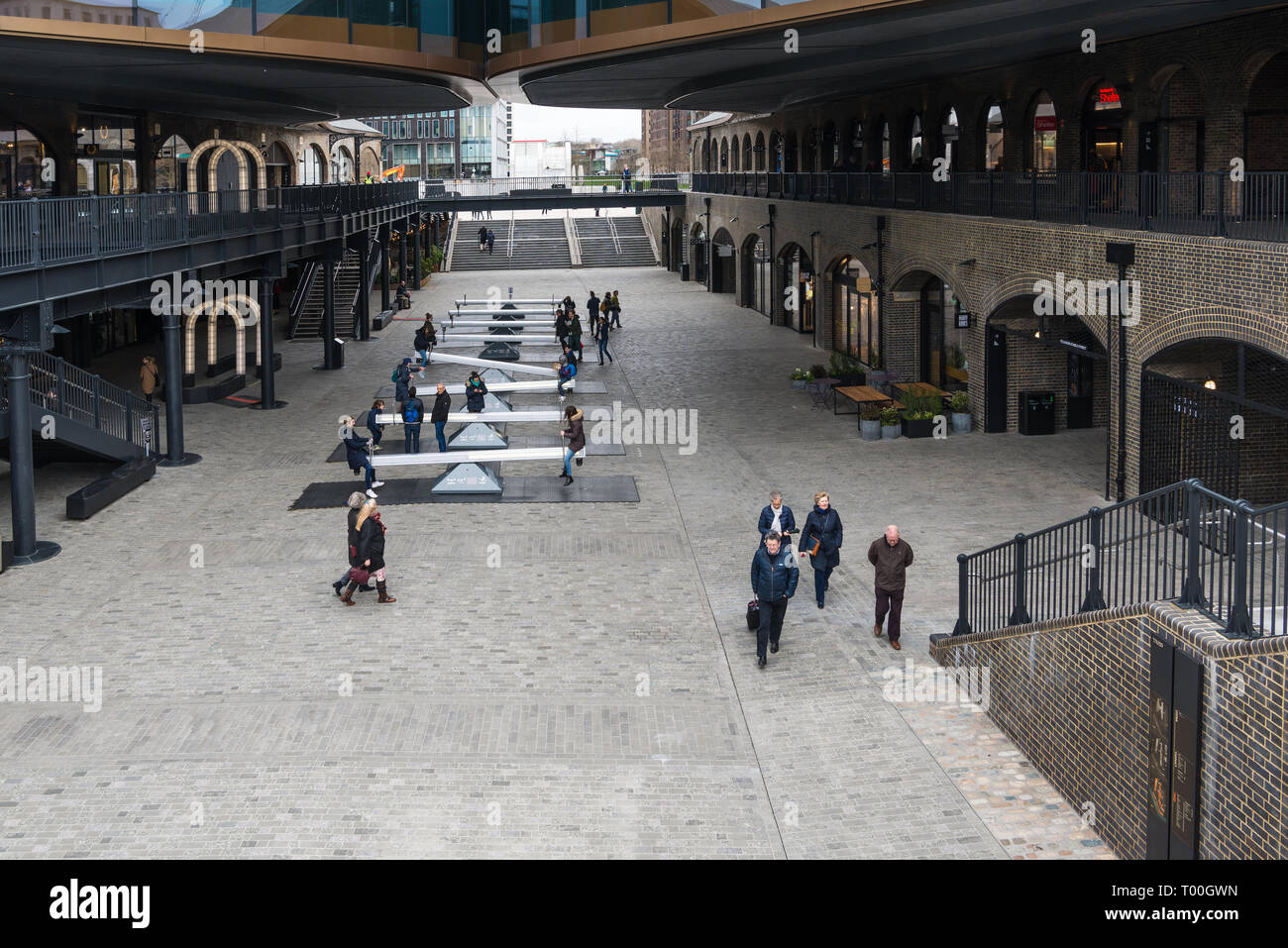 People at Coal Drops Yard, a refurbished area of Victorian buildings converted into shops, restaurants and leisure facilities, Kings Cross, London Stock Photo