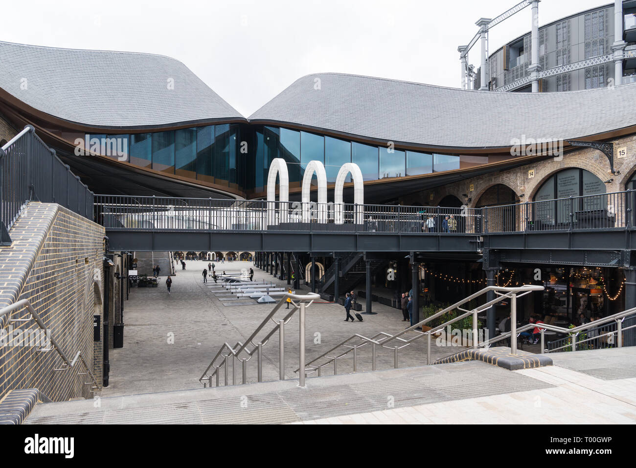 People at Coal Drops Yard, a refurbished area of Victorian buildings converted into shops, restaurants and leisure facilities, Kings Cross, London Stock Photo