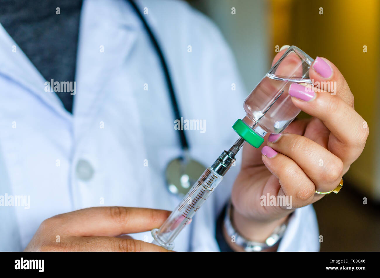Woman doctor nurse drawing vaccine medicine in injection syringe Stock Photo