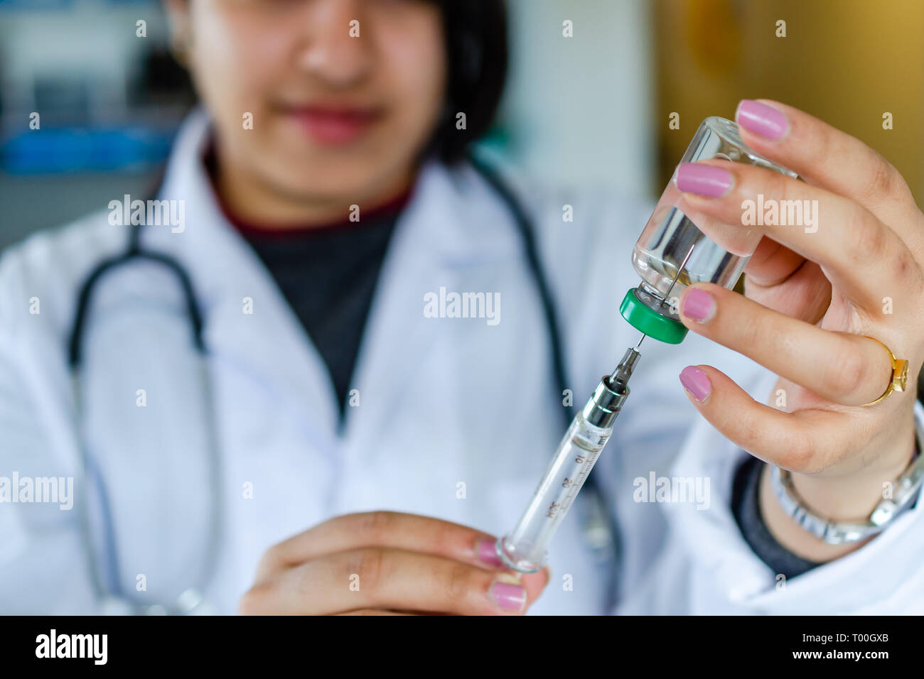 Woman doctor nurse drawing vaccine medicine in injection syringe Stock Photo