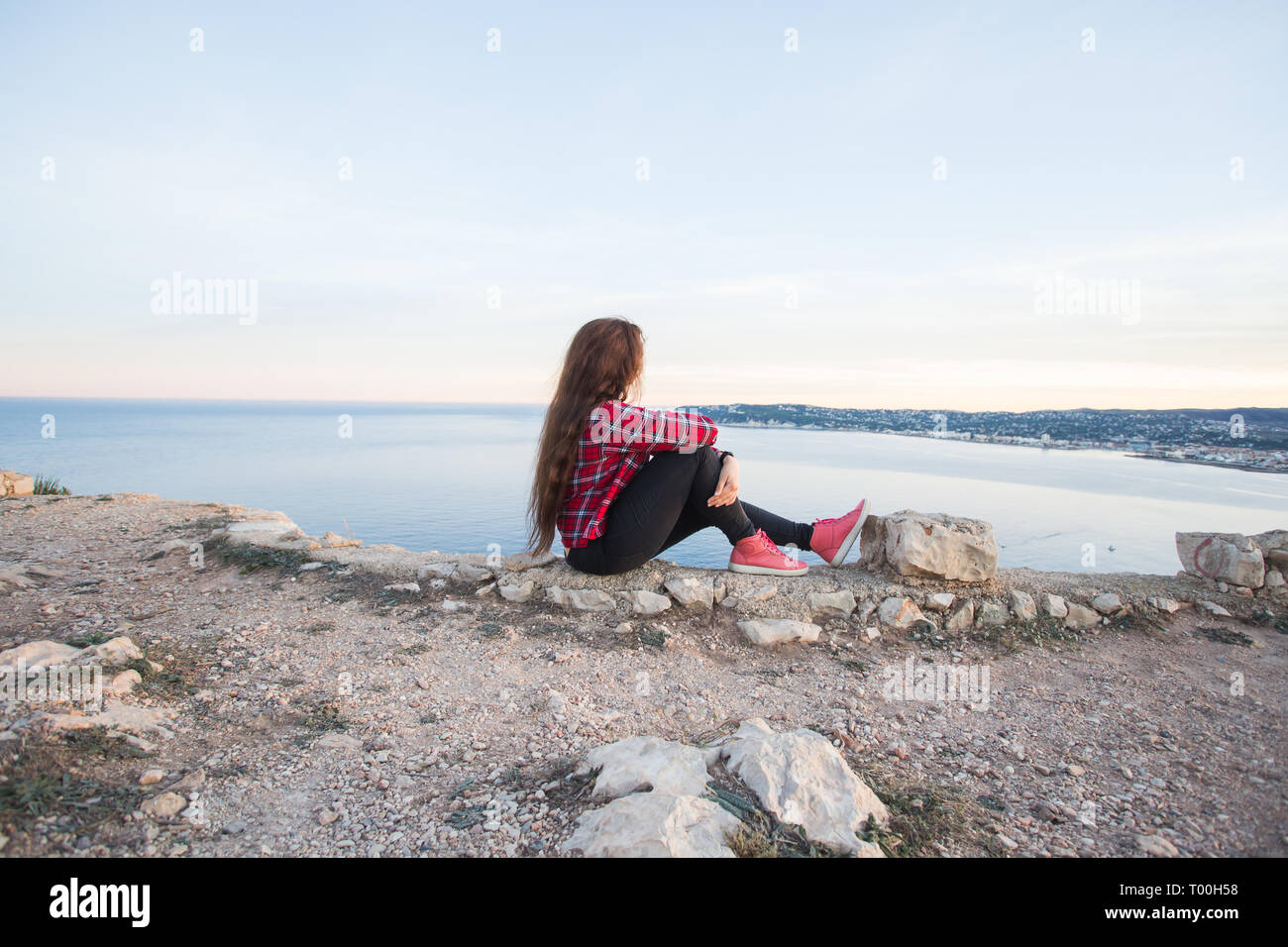 Travel, adventures and loneliness concept - A girl sits on the edge of ...