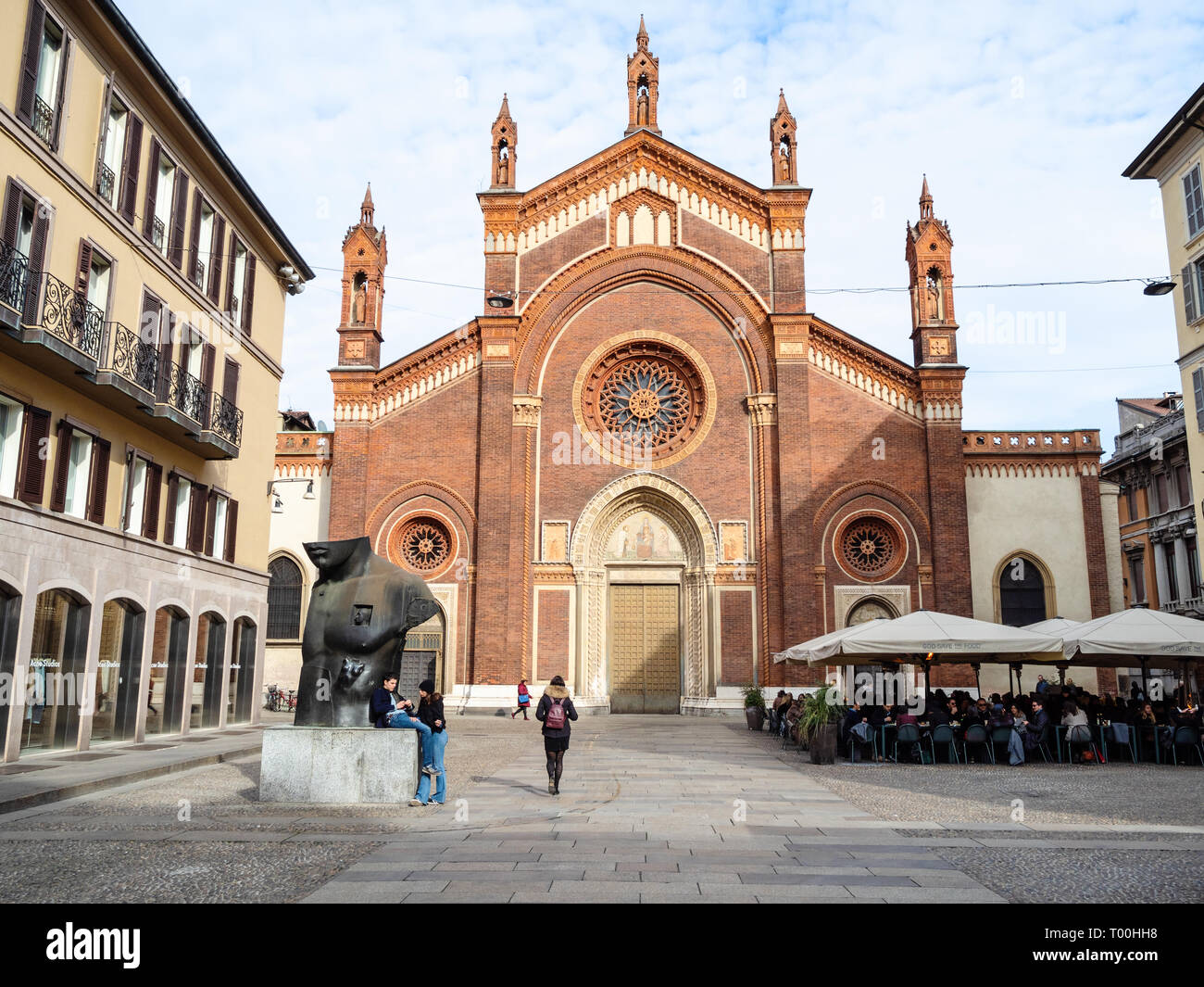 MILAN, ITALY - FEBRUARY 24, 2019: people and modern sculpture Chest in Half by Igor Mitoraj on square Piazza del Carmine with church Chiesa di Santa M Stock Photo