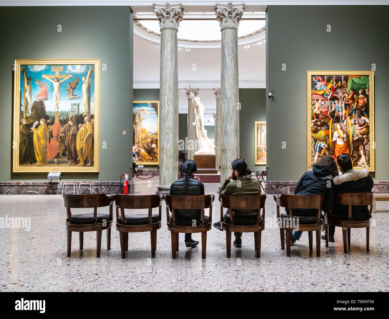 MILAN, ITALY - FEBRUARY 24, 2019: visitors sit in hall in Pinacoteca di Brera (Brera Art Gallery) in Milan. The Brera is national picture gallery of a Stock Photo