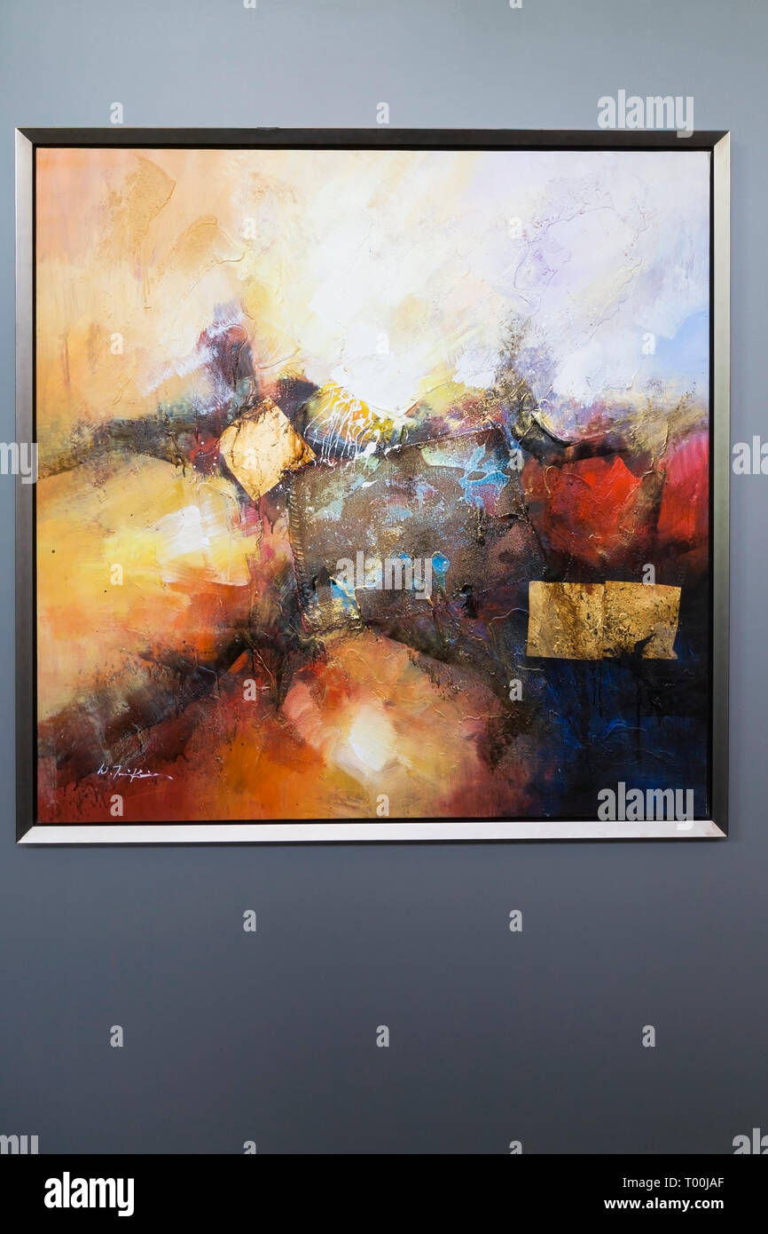 Framed abstract painting on grey wall of hallway inside a luxurious contemporary bungalow style