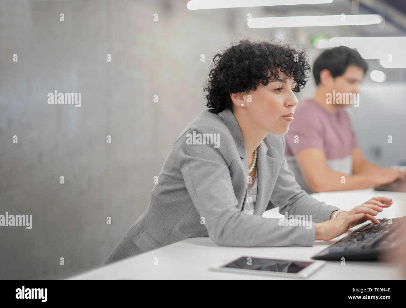 young female software developer using desktop computer while writing programming code at modern creative startup office Stock Photo