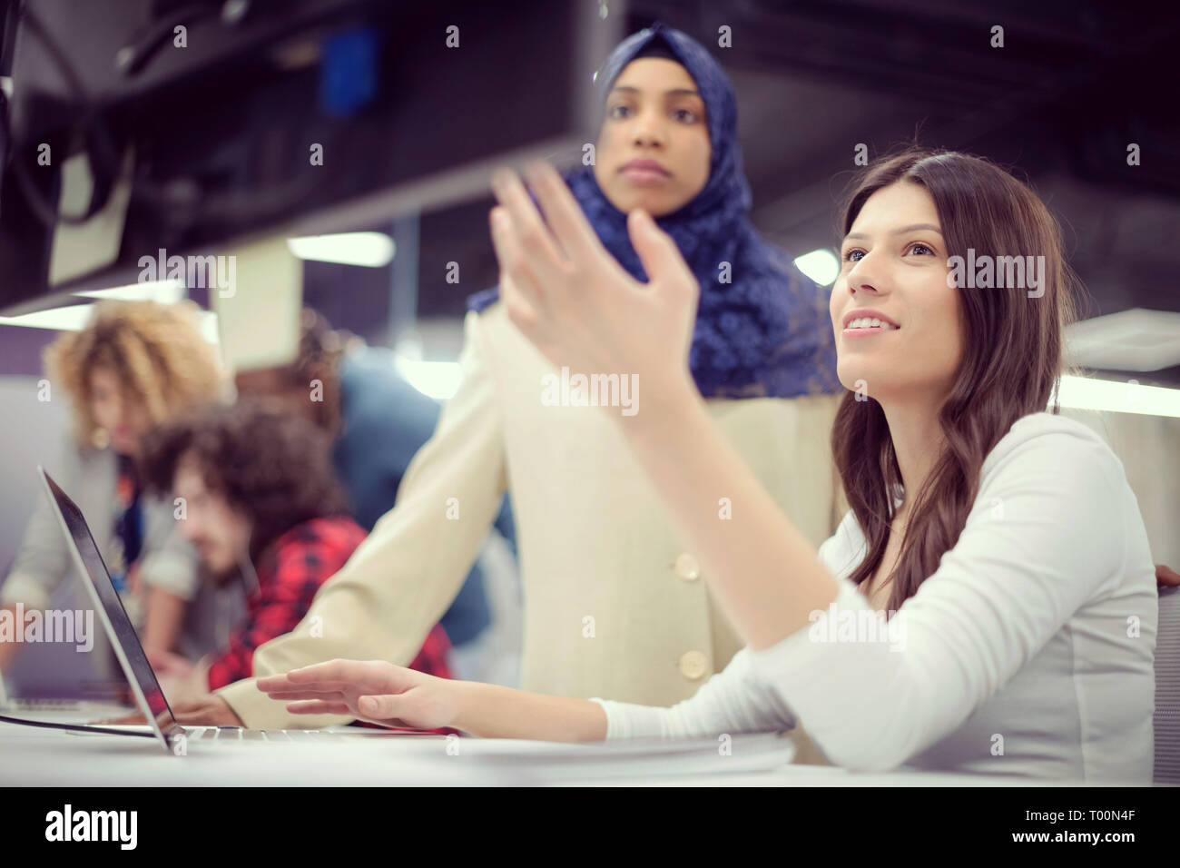 young multiethnics business team of software developers working together using laptop computer while writing programming code at modern startup office Stock Photo