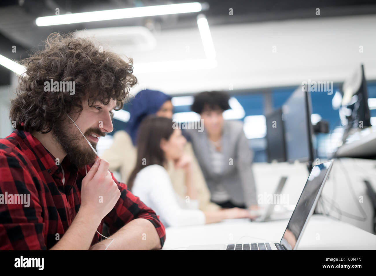 young multiethnics business team of software developers working together using laptop and desktop computer while writing programming code at modern st Stock Photo