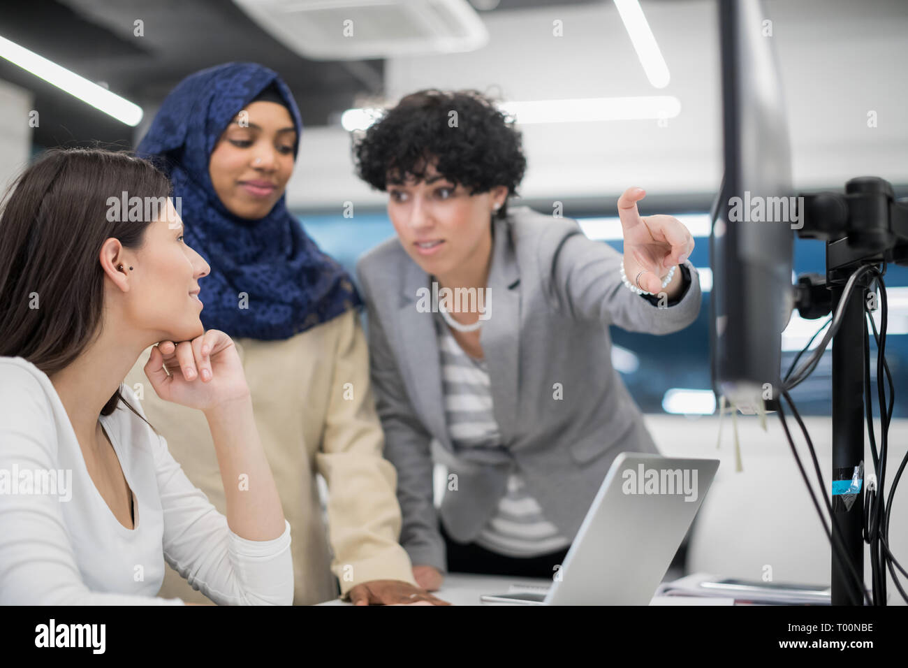 young multiethnics business team of software developers working together using laptop computer while writing programming code at modern startup office Stock Photo