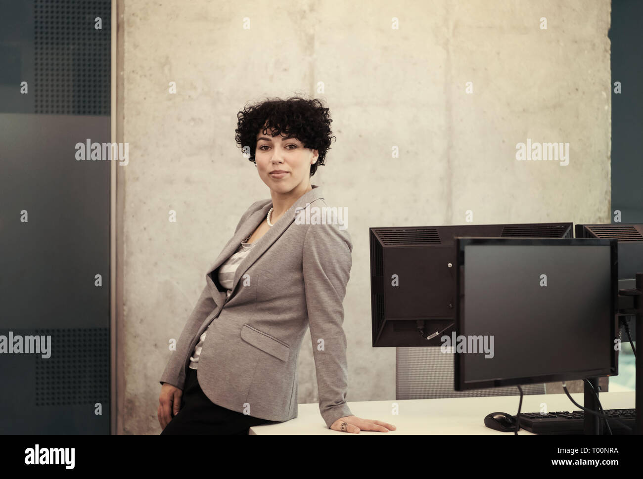 Portrait of successful female software developer with a curly hairstyle ...