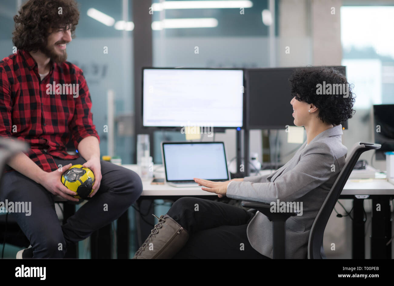 young software developers couple using laptop and desktop computer while writing programming code at modern creative startup office Stock Photo