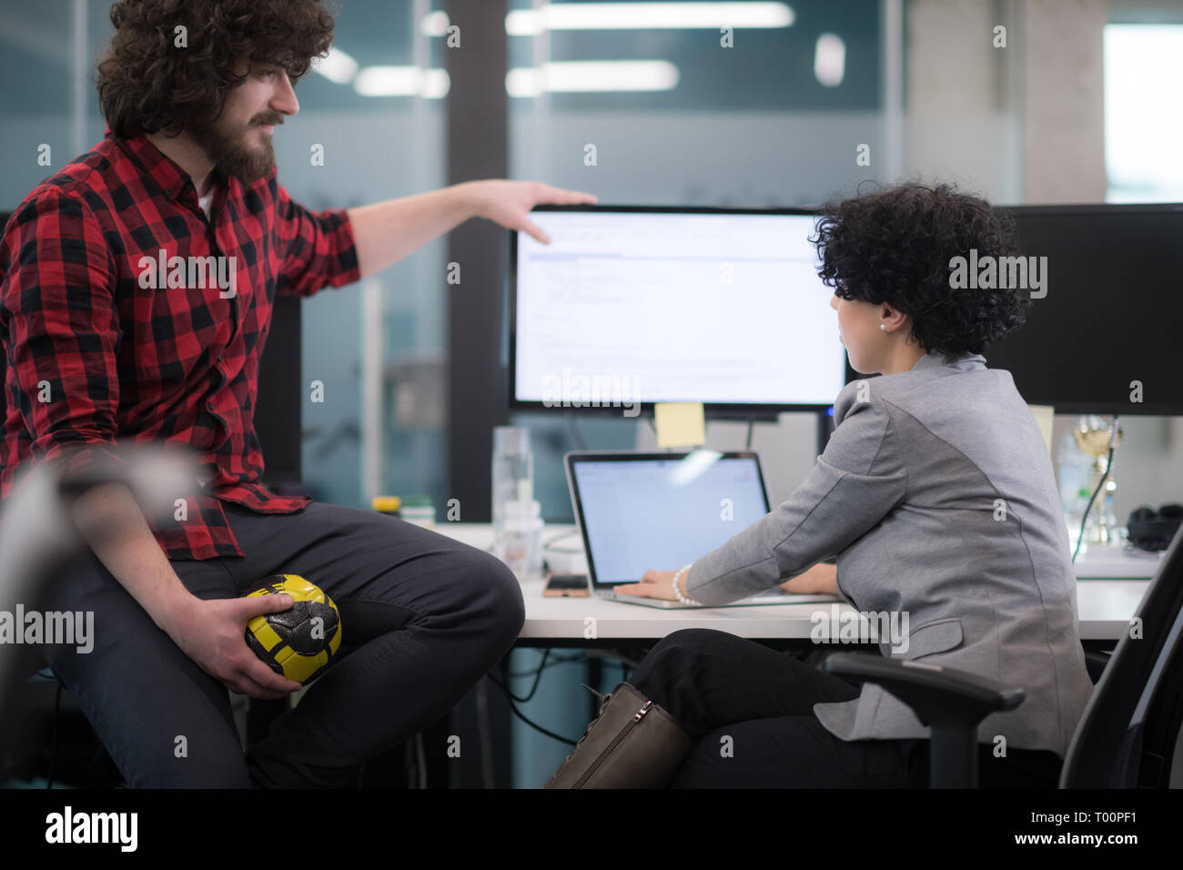 young software developers couple using laptop and desktop computer while writing programming code at modern creative startup office Stock Photo