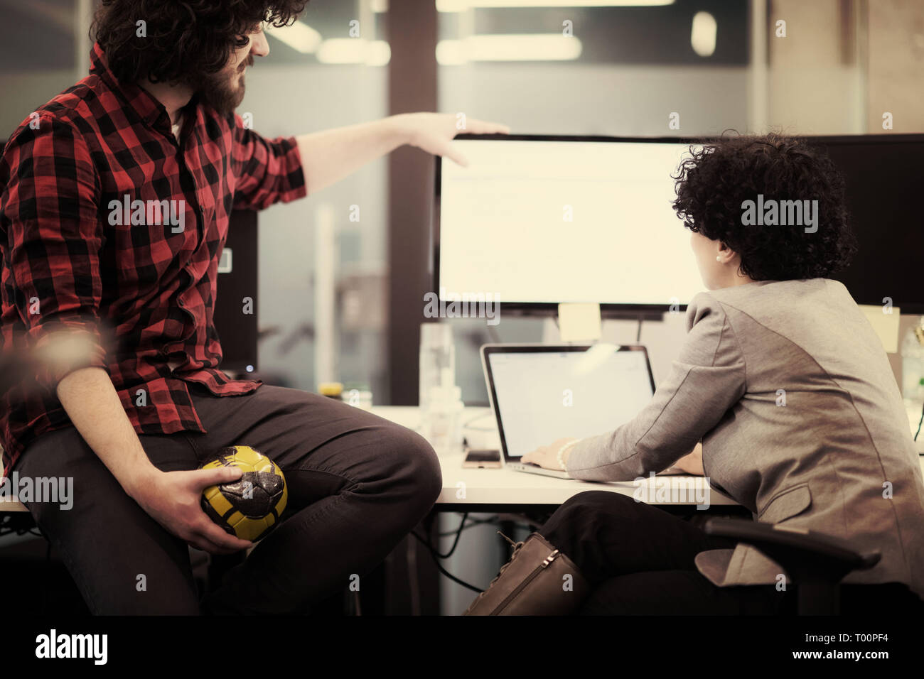 young software developers couple using laptop and desktop computer while writing programming code at modern creative startup office Stock Photo