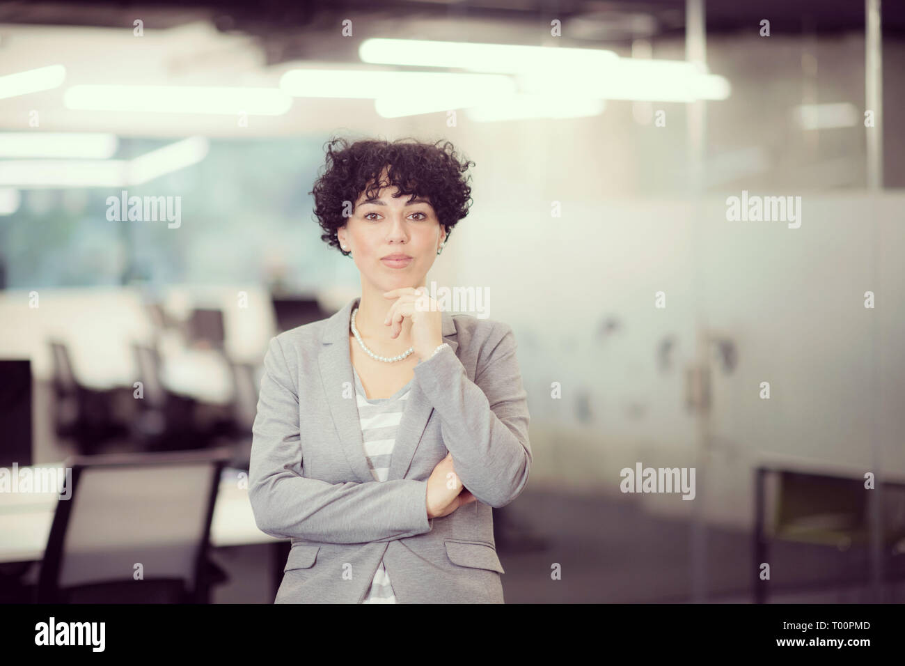 Portrait of successful female software developer with a curly hairstyle at  modern startup office Stock Photo - Alamy