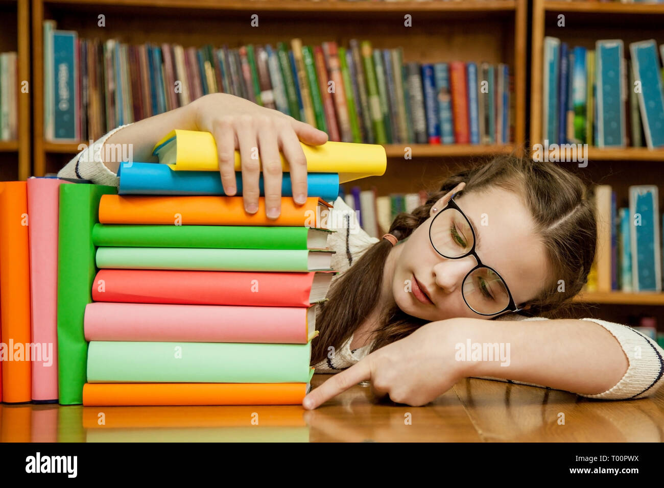 A girl with glasses counts how many books Stock Photo Alamy