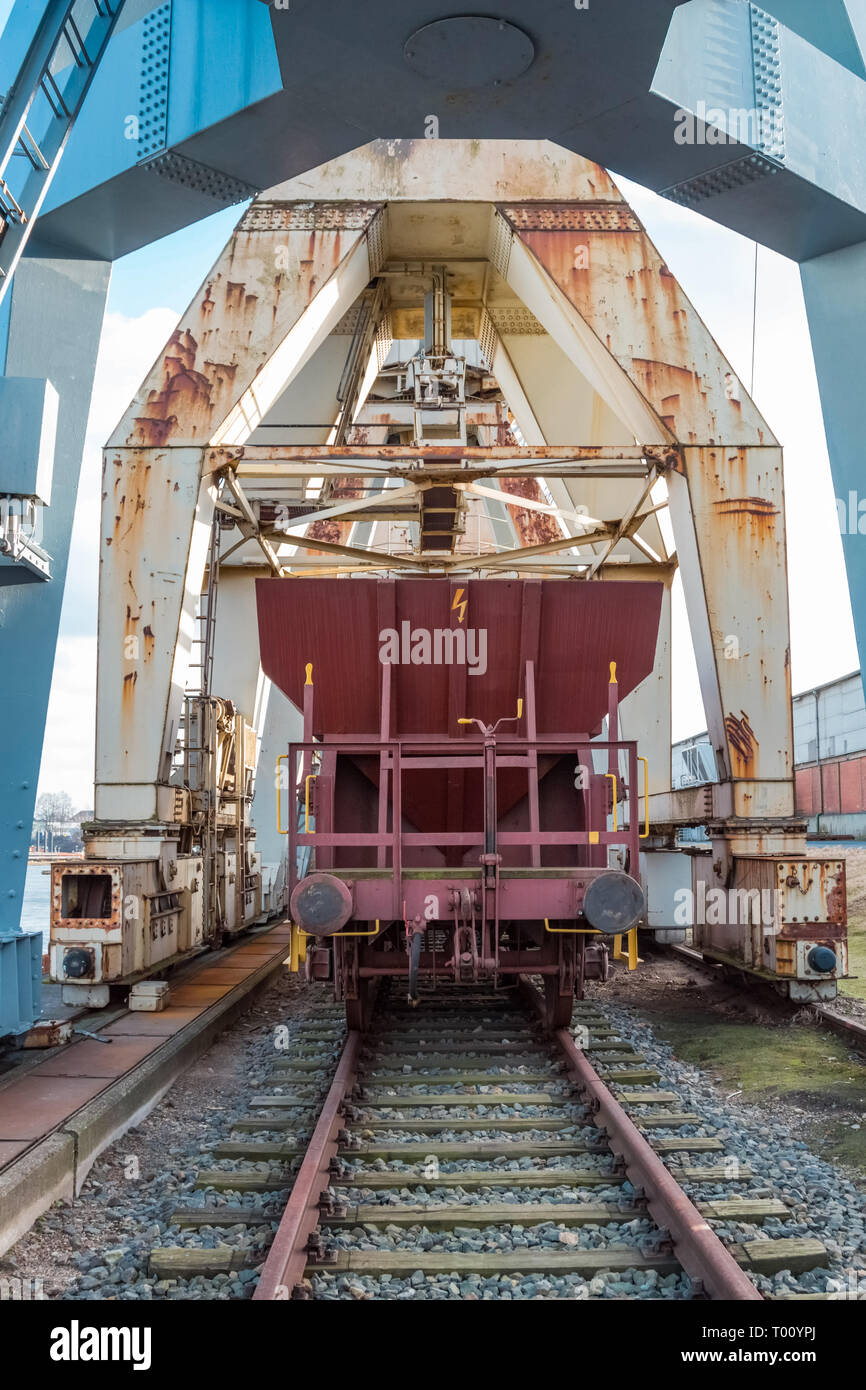Freight car unloading under a working crane Stock Photo