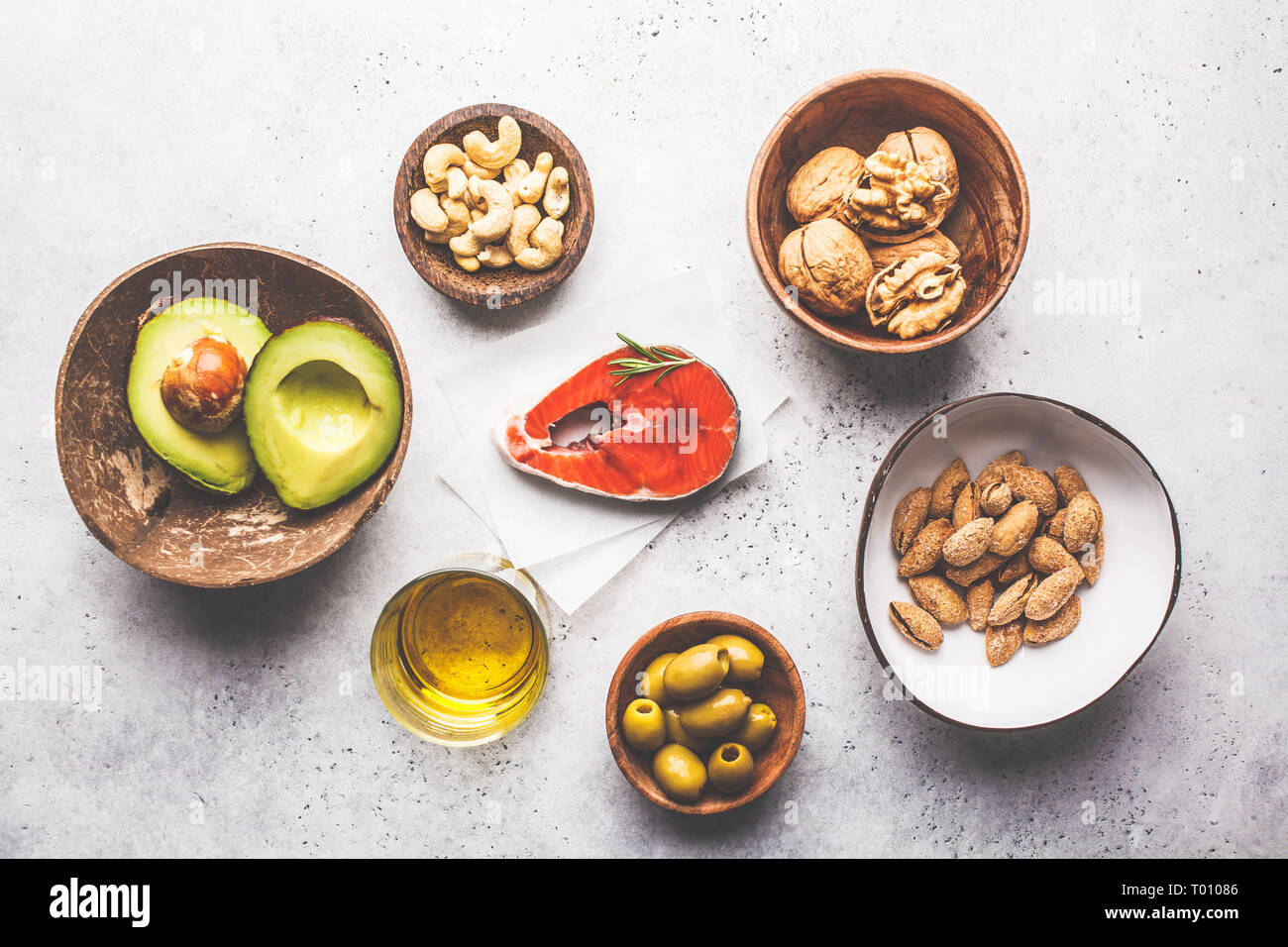 Selection of healthy fat sources fish, nuts, oil, olives, avocado on