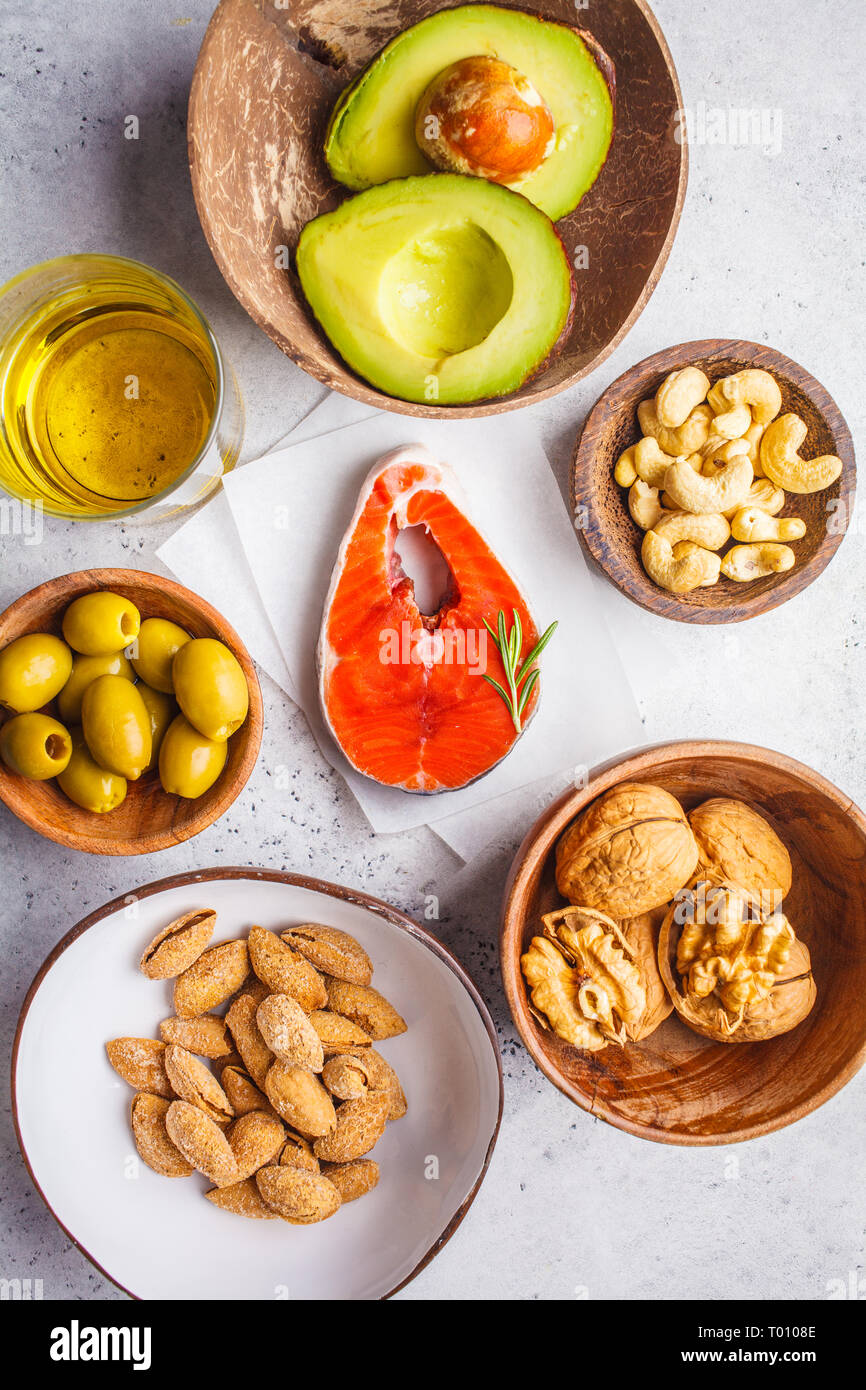 Selection of healthy fat sources fish, nuts, oil, olives, avocado on