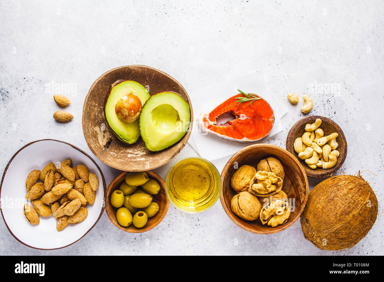 Selection of healthy fat sources fish, nuts, oil, olives, avocado on