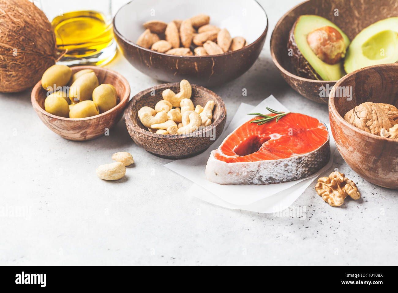 Selection of healthy fat sources fish, nuts, oil, olives, avocado on